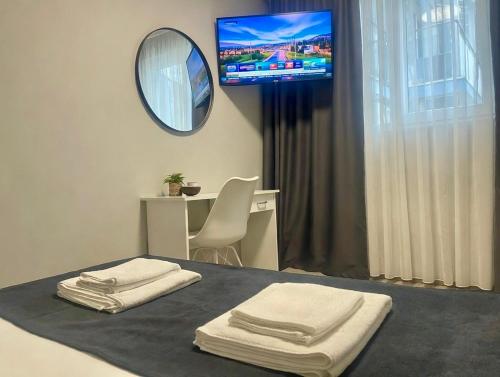 a room with a bed with a mirror and a tv at HOTEL ESKADA BEACH - Free Parking in Ahtopol