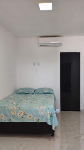 a bedroom with a bed with a blue comforter at Mirian nascimento in Camaçari