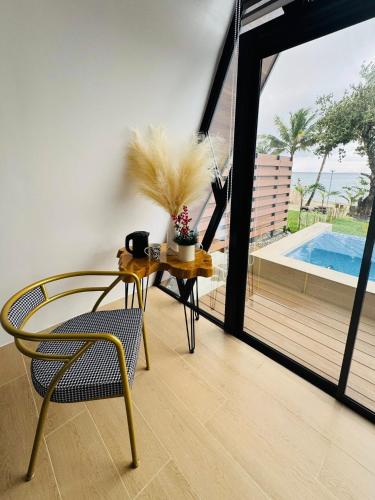 a dining room with a table and chairs and a pool at Solsticio Azzul Beach Resort in Pandan
