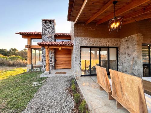 a patio of a house with chairs in front of it at BOSK TAPALPA - Cabaña en Tapalpa in Tapalpa
