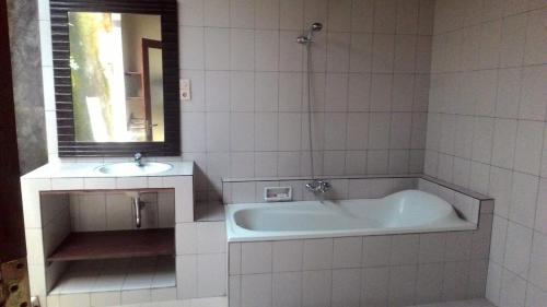 a white bathroom with a tub and a sink at Kubu shanti 1 in Ubud
