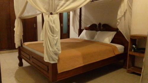 a bedroom with a bed with a canopy at Kubu shanti 1 in Ubud