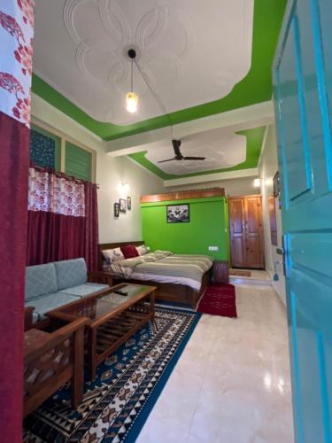 a living room with a couch and a green wall at The Moon Light Home stay in Bhīm Tāl