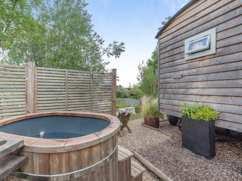 a hot tub in a garden next to a fence at Herbie's Shepherd Hut - Uk50229 in Nottingham