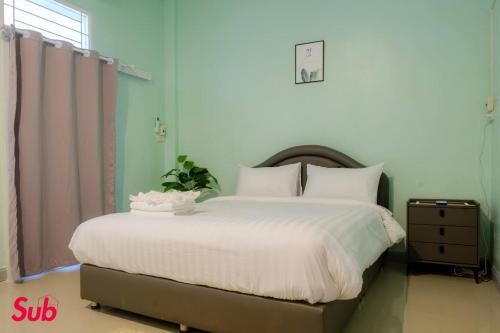 a bedroom with a large bed with white sheets at Dream Home in Hat Yai in Ban Kohong