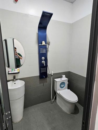 a small bathroom with a toilet and a mirror at Lê Gia HOUSE KG in Kiên Lương