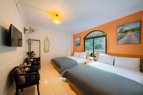 a hotel room with two beds and a window at Napoli Hostel Cat Ba in Cat Ba