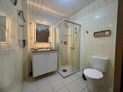 a bathroom with a shower and a toilet and a sink at Encantos no Porto da Barra in Salvador
