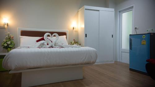 a bedroom with a bed with two swans on it at Namthip Residence in Trang