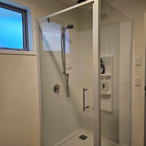 a shower with a glass door in a bathroom at Seventy-Four on Ramsay in Taupo