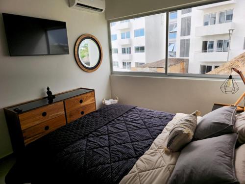 a bedroom with a bed and a large window at Bluu lagoons in Los Cerritos