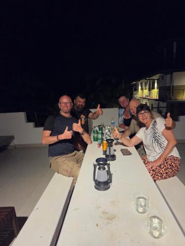 a group of people sitting around a table at Ceylon Lodge - Airport Transit Hostel in Negombo