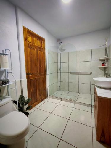 a bathroom with a toilet and a shower and a sink at Mystic Solarium Private Indoor Pool in Chachagua