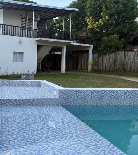 a blue tile swimming pool in front of a house at V&V House in Concordia