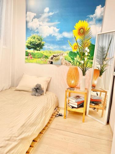 a bedroom with a bed and a painting of a sunflower at Finetree House in Samgong