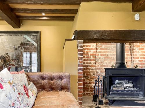 a living room with a couch and a fireplace at Oaklands Farm - Cottage 5 in Broughton