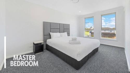 a bedroom with a large bed and a large window at Little Gem in Northwest! in Riverstone