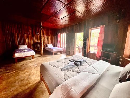 a bedroom with a large bed in a room at บ้านชนเผ่าแคมปิ้งแอนด์รีสอร์ท in Pang Mapha