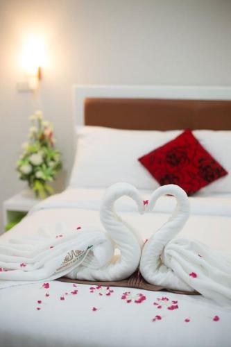 two white swans making a heart on a bed at Namthip Residence in Trang