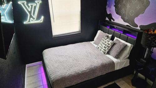 a bedroom with a bed with neon lights at The Gawdy Den with Fast WIFI 2 minutes from Downtown Houston! in Houston