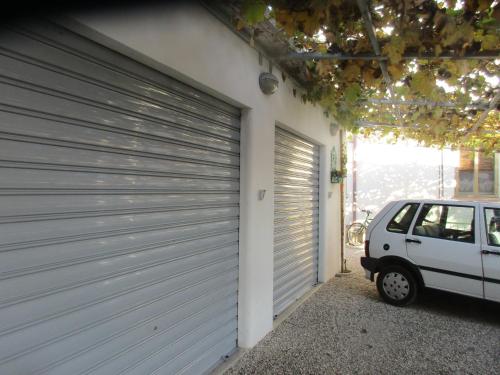 a white car parked next to a garage door at CASA ROMAN ITALIA, Center Sacile in Sacile