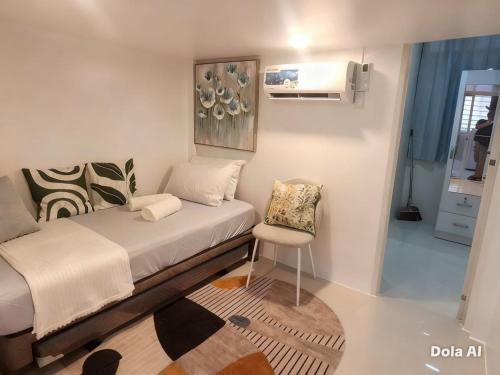 a small bedroom with a bed and a chair at Prime World District Condo in Pajak