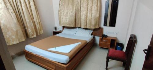 a bedroom with a bed and a red chair at amb guest house in Chennai