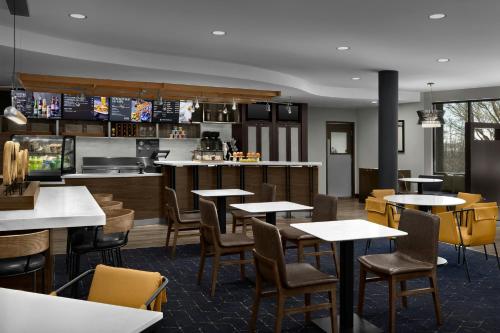 a restaurant with tables and chairs and a kitchen at Courtyard Danville in Danville