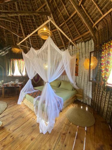a bedroom with a bed with mosquito nets on it at Baobab Lagoon in Mtende