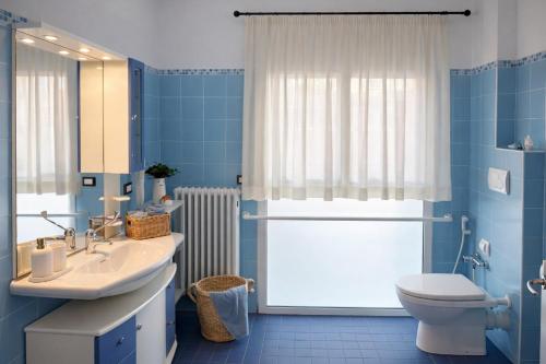 a blue bathroom with a sink and a toilet at Residence I Delfini in Cupra Marittima