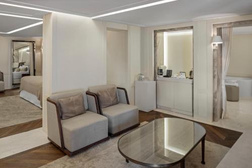 a living room with two chairs and a glass table at Kemer Country Hotel İstanbul in Istanbul