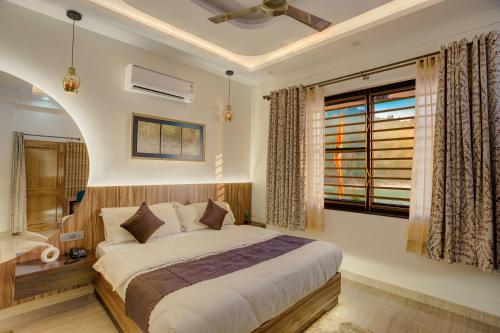 a bedroom with a large bed and a window at Sharnam On The Ganges in Rishīkesh