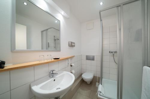 un baño blanco con lavabo y ducha en Hotel 26, en Berlín