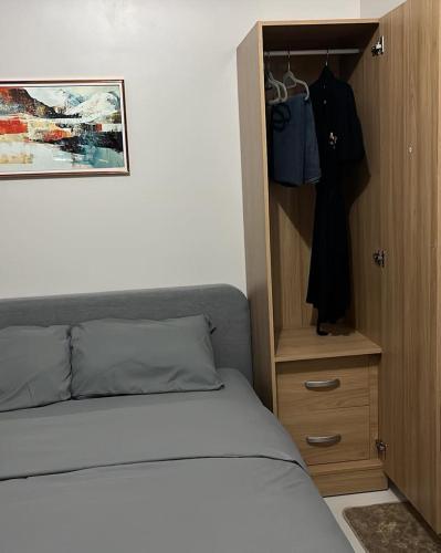 a bedroom with a bed and a wooden cabinet at MERE Suite Davao- One Lakeshore behind SM Lanang in Davao City