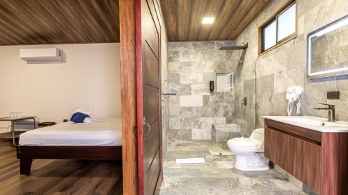 a bathroom with a shower and a toilet and a sink at Termales del Arenal in Fortuna