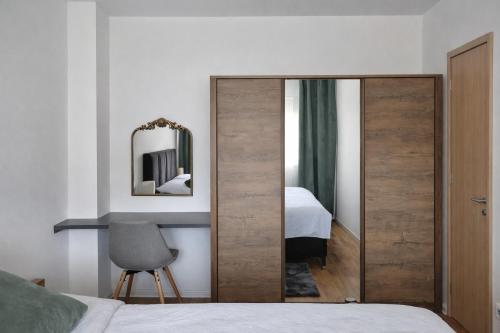 a bedroom with a sliding door with a mirror at Hari Apartmani Oaza in Tuzla