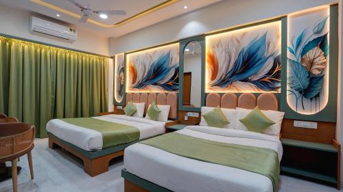 a hotel room with two beds and a painting on the wall at Hotel Balaji Residency Dombivali in Dombivli