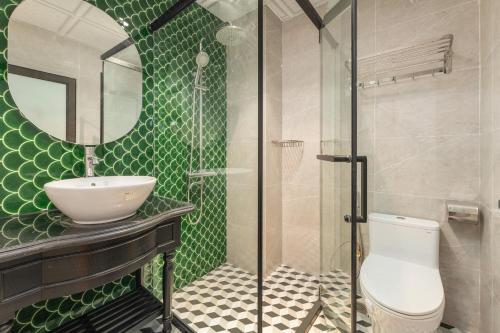 a bathroom with a sink and a toilet and a mirror at Aurora Hotel & Apartment in Hanoi