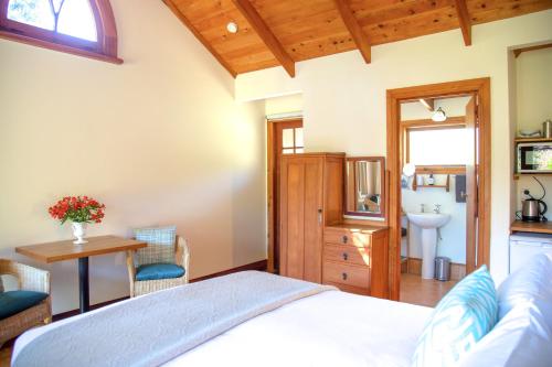 a bedroom with a bed and a table and a sink at The Church Accommodation in Hahei
