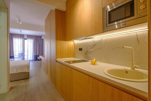 a bathroom with a sink and a microwave at Dubrave apartmani in Budva
