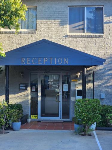 a blue awning over the entrance to a building at Crest Motor Inn in Queanbeyan