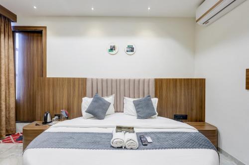 a bedroom with a large bed with slippers on it at Hotel Lee Paramount in Gandhinagar