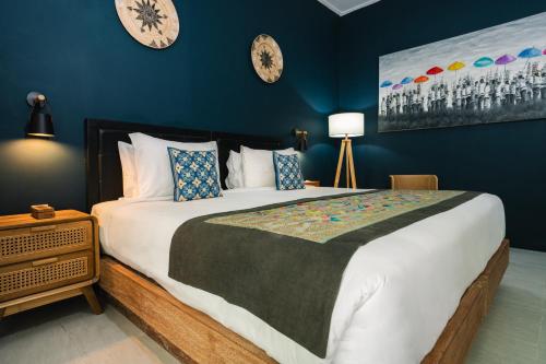 a bedroom with a large bed and clocks on the wall at Sanur House in Sanur