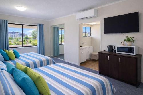 a hotel room with two beds and a television at Coastal Breeze Studio Near Stadium, Ferry Marina in Townsville