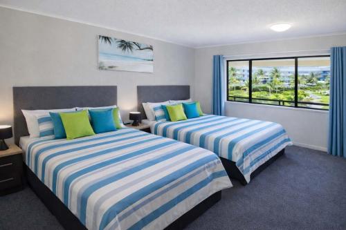 two beds in a room with a window at Coastal Breeze Studio Near Stadium, Ferry Marina in Townsville