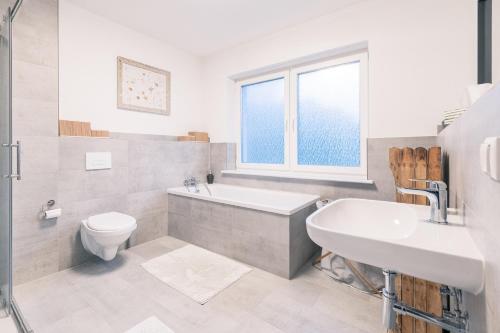 ein Badezimmer mit Badewanne, Waschbecken und Toilette in der Unterkunft Haus Emma Großes Ferienhaus mit Garten für bis zu 10 Personen in Klosterdorf
