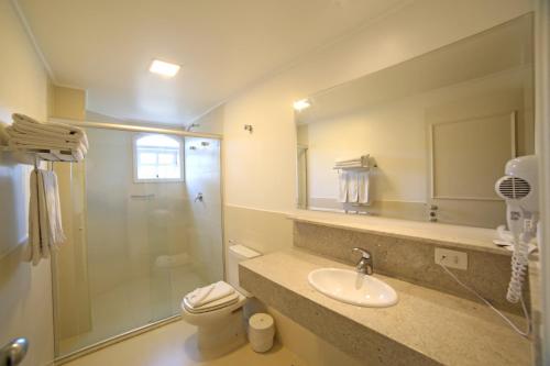 La salle de bains est pourvue d'une douche, d'un lavabo et de toilettes. dans l'établissement Moinho Itália Hotel, à Campos do Jordão
