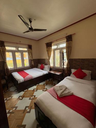 a bedroom with three beds and a ceiling at Hotel Shera Pokhara in Pokhara