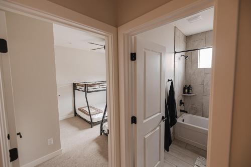 a bathroom with a walk in shower and a tub at The Mustang Collection 55 in Page