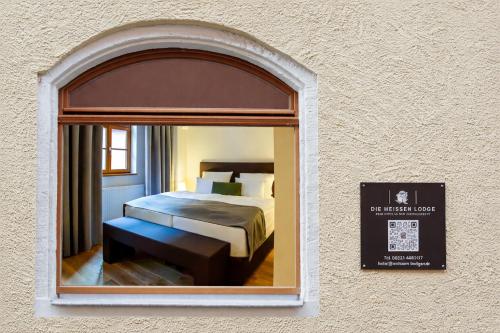 a bedroom with a bed and a mirror in a wall at Die Meissen Lodge in Meißen